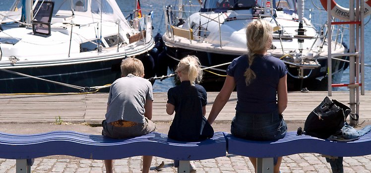 Kvinna med två barn på en bänk i Kalmar gästhamn.